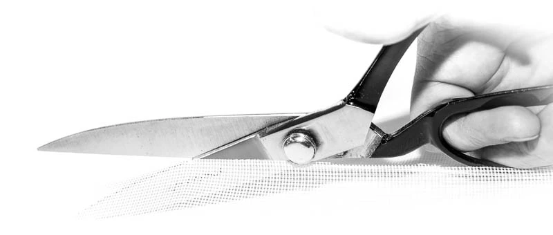 Schere schneidet Gardinenstoff